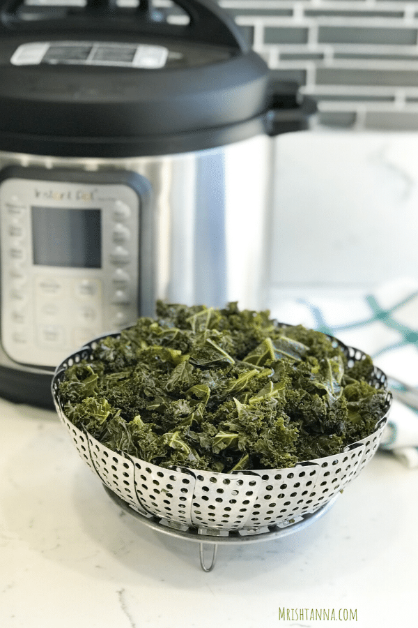 A bowl of steamed kale is on the table