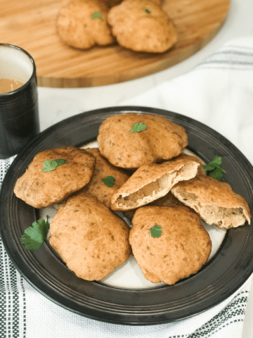 A plate of food on a table, with Puri and Mangalore buns