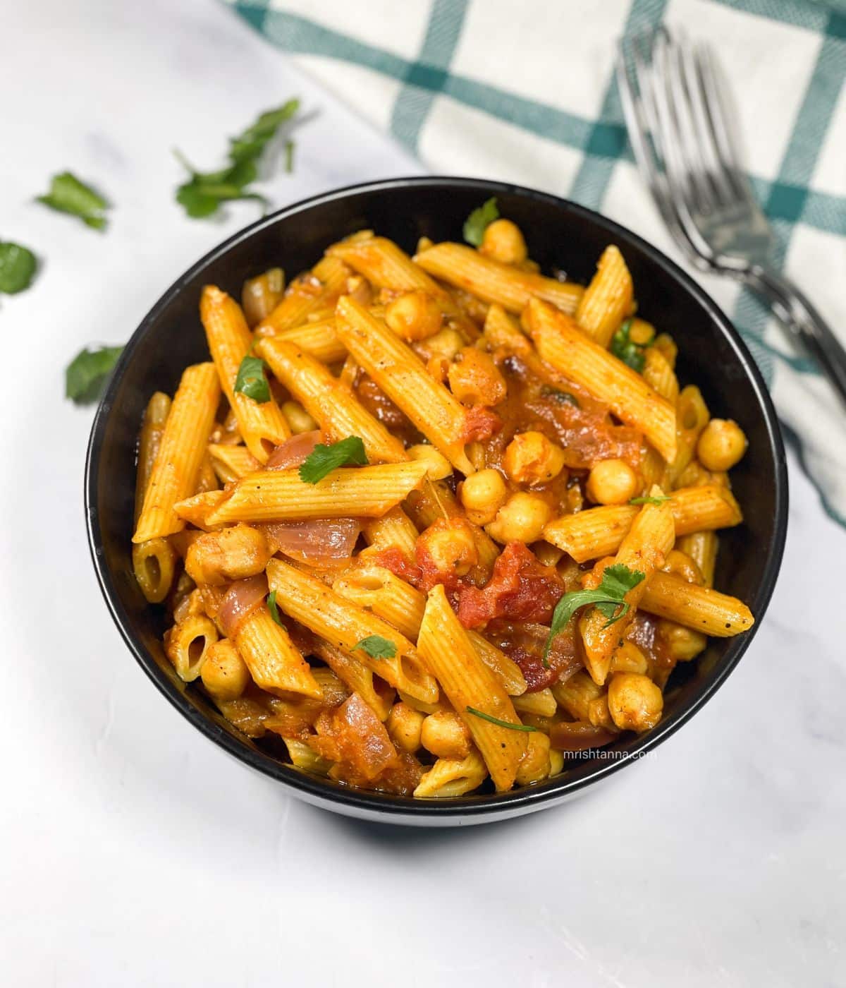 A bowl of tikka masala pasta is on the table.