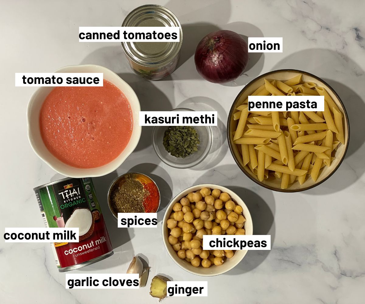 A table is full of tikkka masala pasta ingredients.