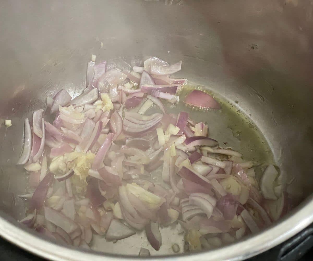 An instant pot has chopped onions.