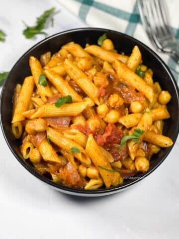 A bowl has tikka masala pasta.