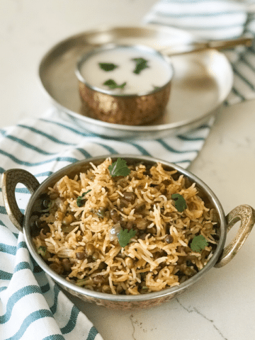 A bowl of rice on a plate, with curd