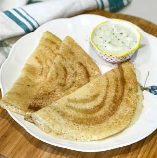 three dosas on a plate along with chutney