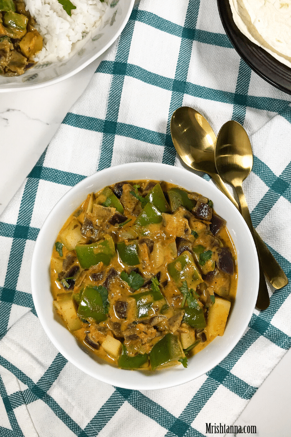 A bowl of food on a plate, with Curry and Potato