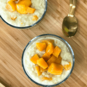 A bowl of food on a plate on a wooden table, with Mango and Rice