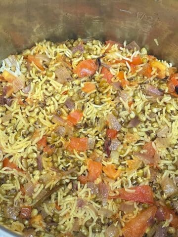 An instant pot is with green moong rice.