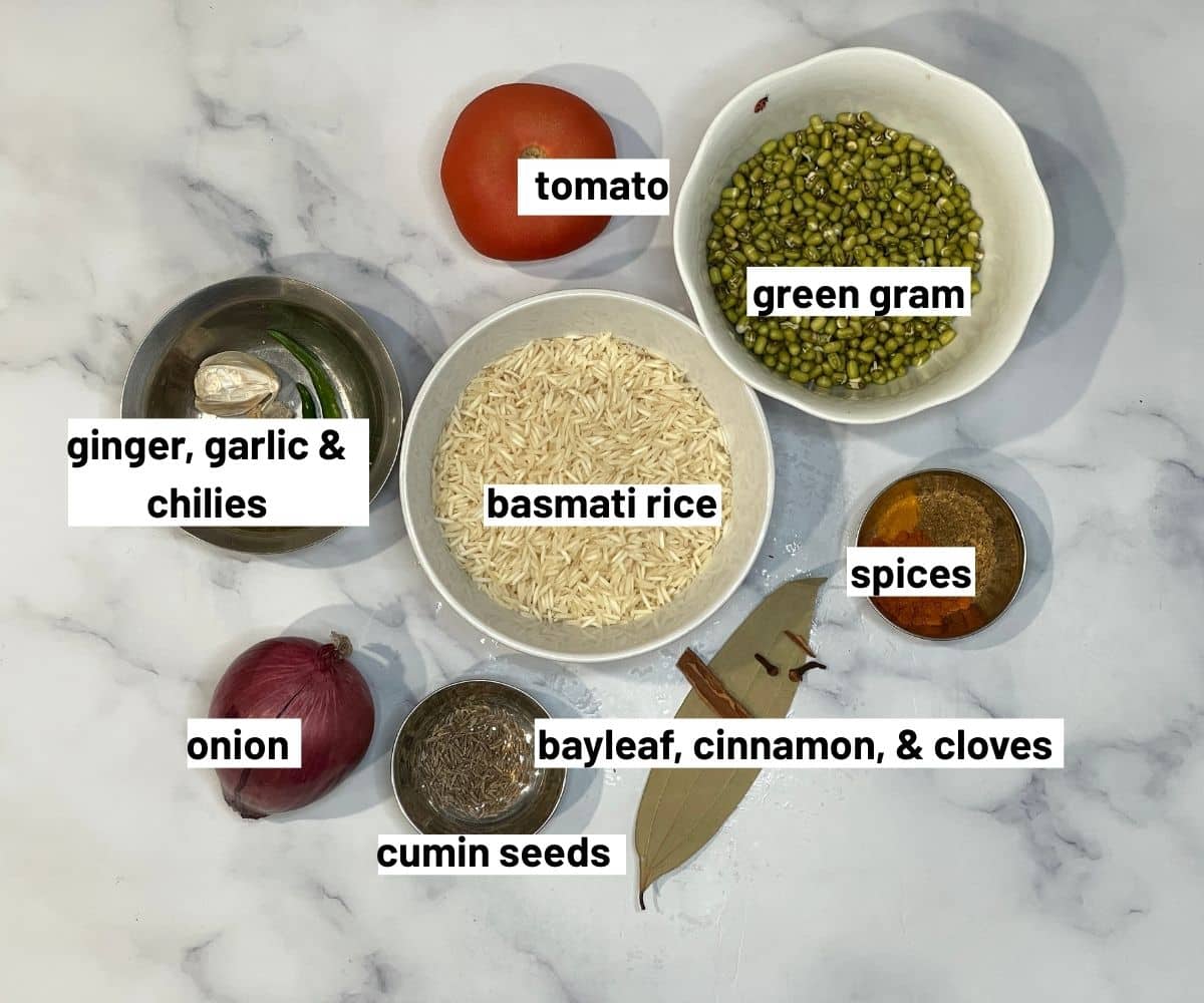 A table is covered with green moong rice recipe ingredients.