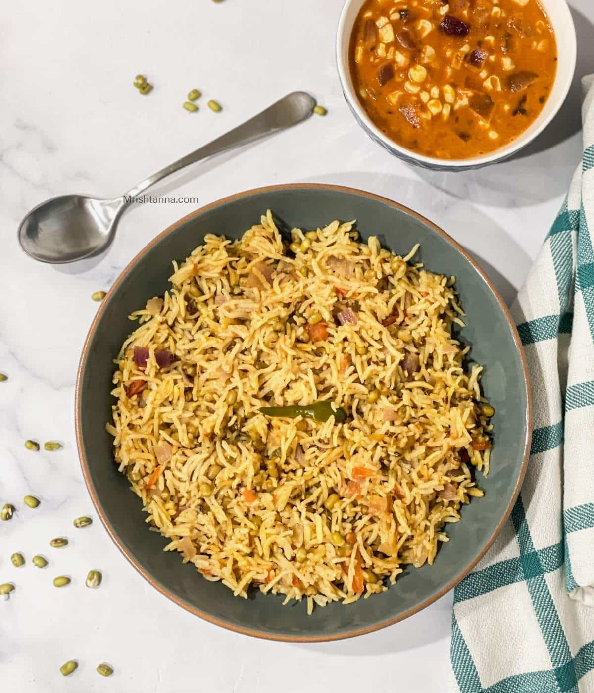 A plate of green moong rice is on the table.