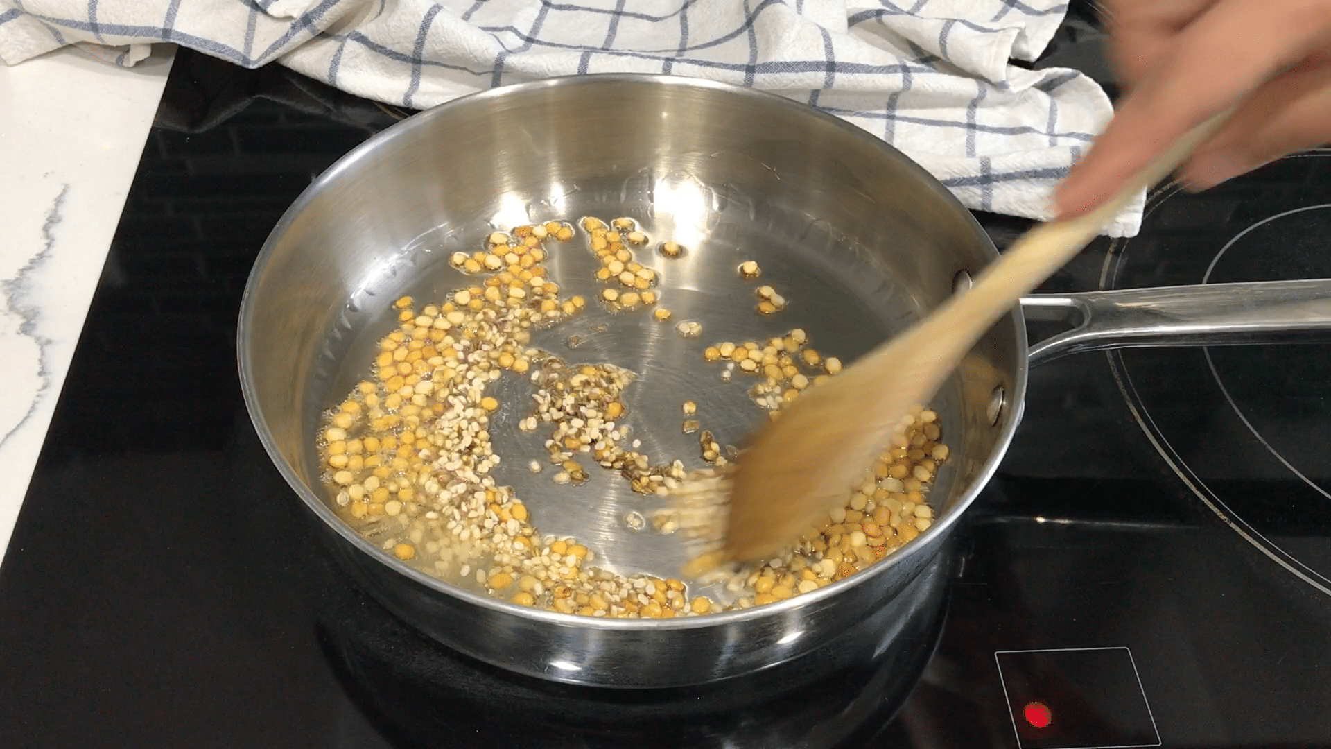 A person cooking food in a pan on a stove, with Chutney and Dosa