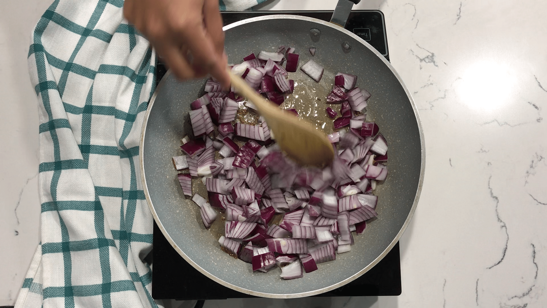 A person stirring a food, with Curry and Potato