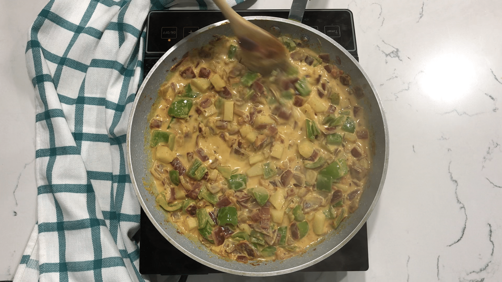 A pan of curry sitting on top of a pan on a table, with Curry and Bell pepper