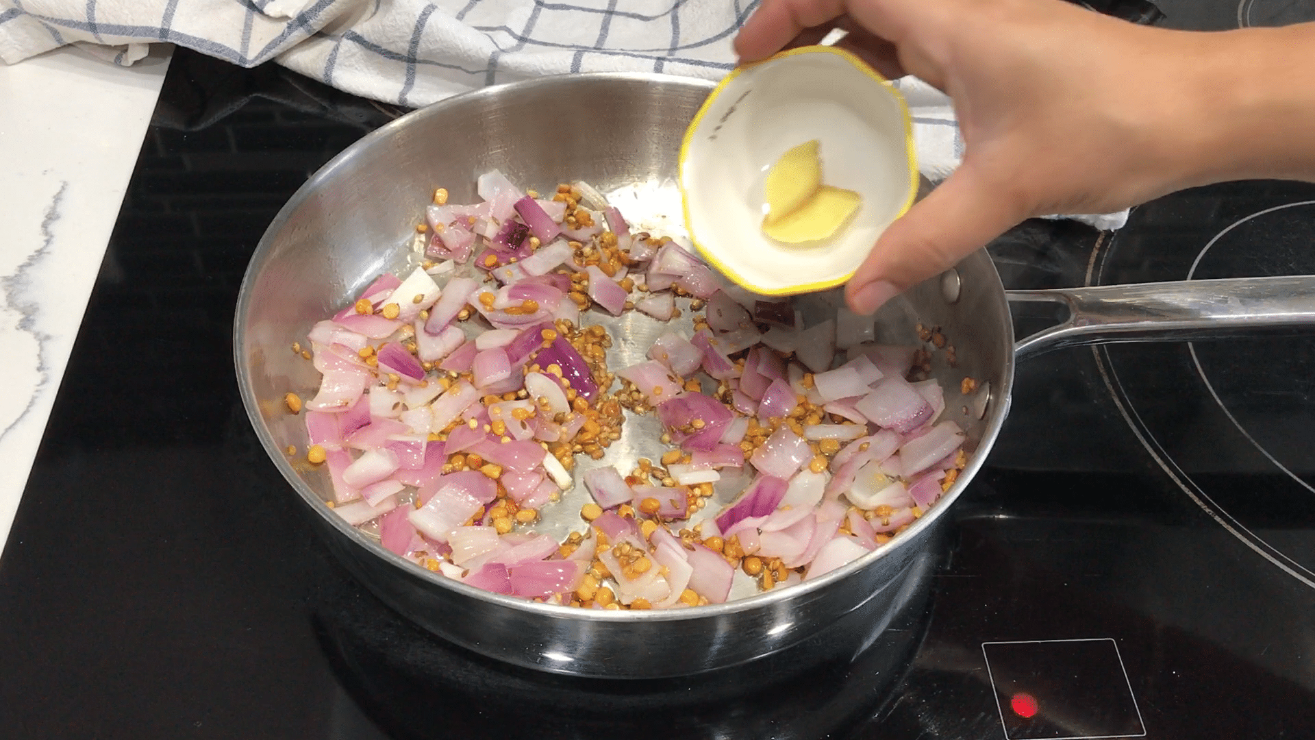 A person cooking food in a bowl, with Chutney and Tomato