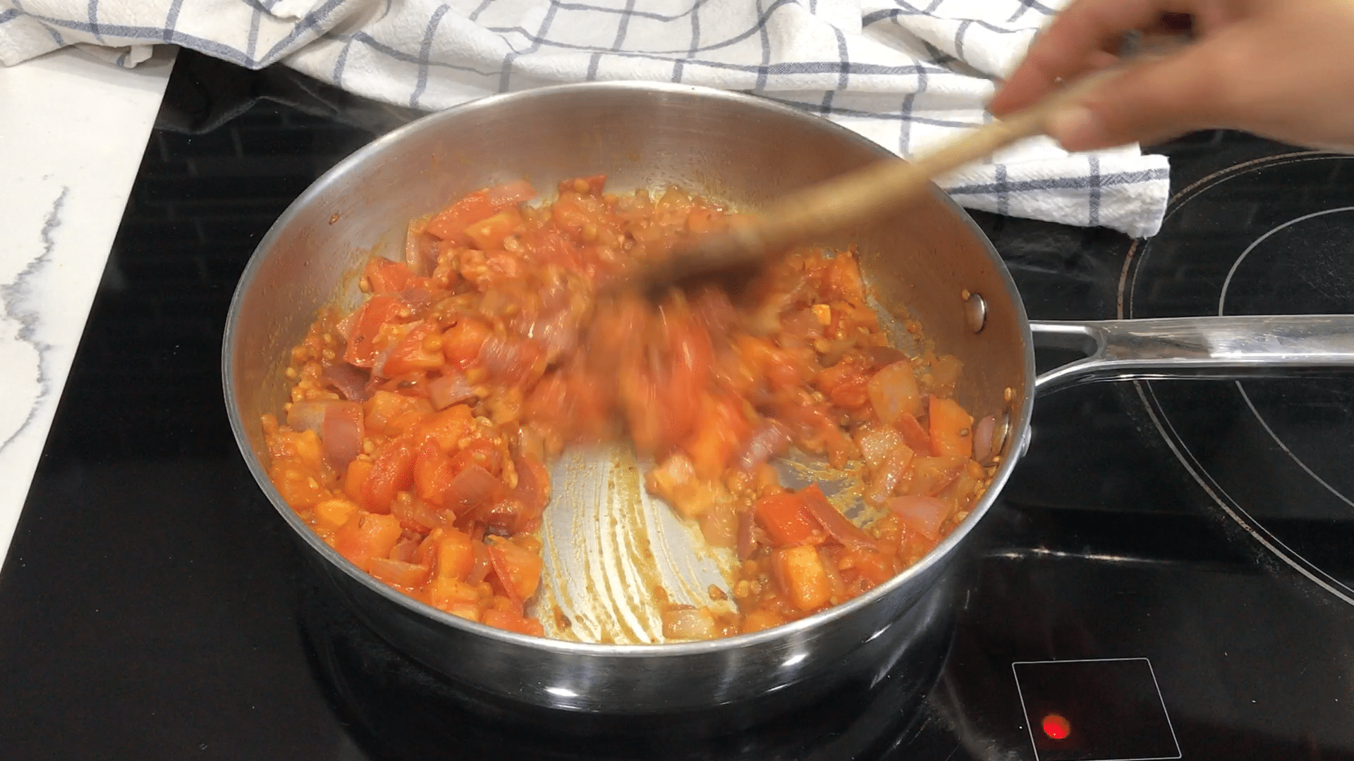 A bowl of food cooking on a stove, with Chutney and Tomato