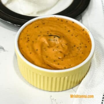 A small bowl of tomato chutney is on the table.