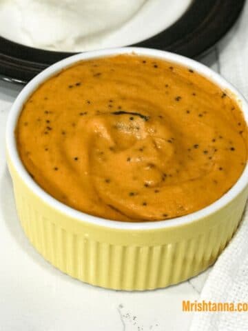 A small bowl of tomato chutney is on the table.