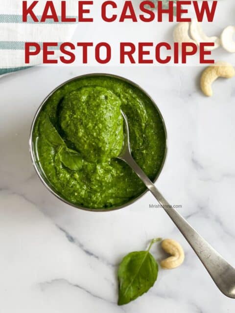 A spoon full of kale cashew pesto on the pesto bowl.