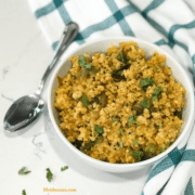 A bowl of food on a plate, with Millet and Upma