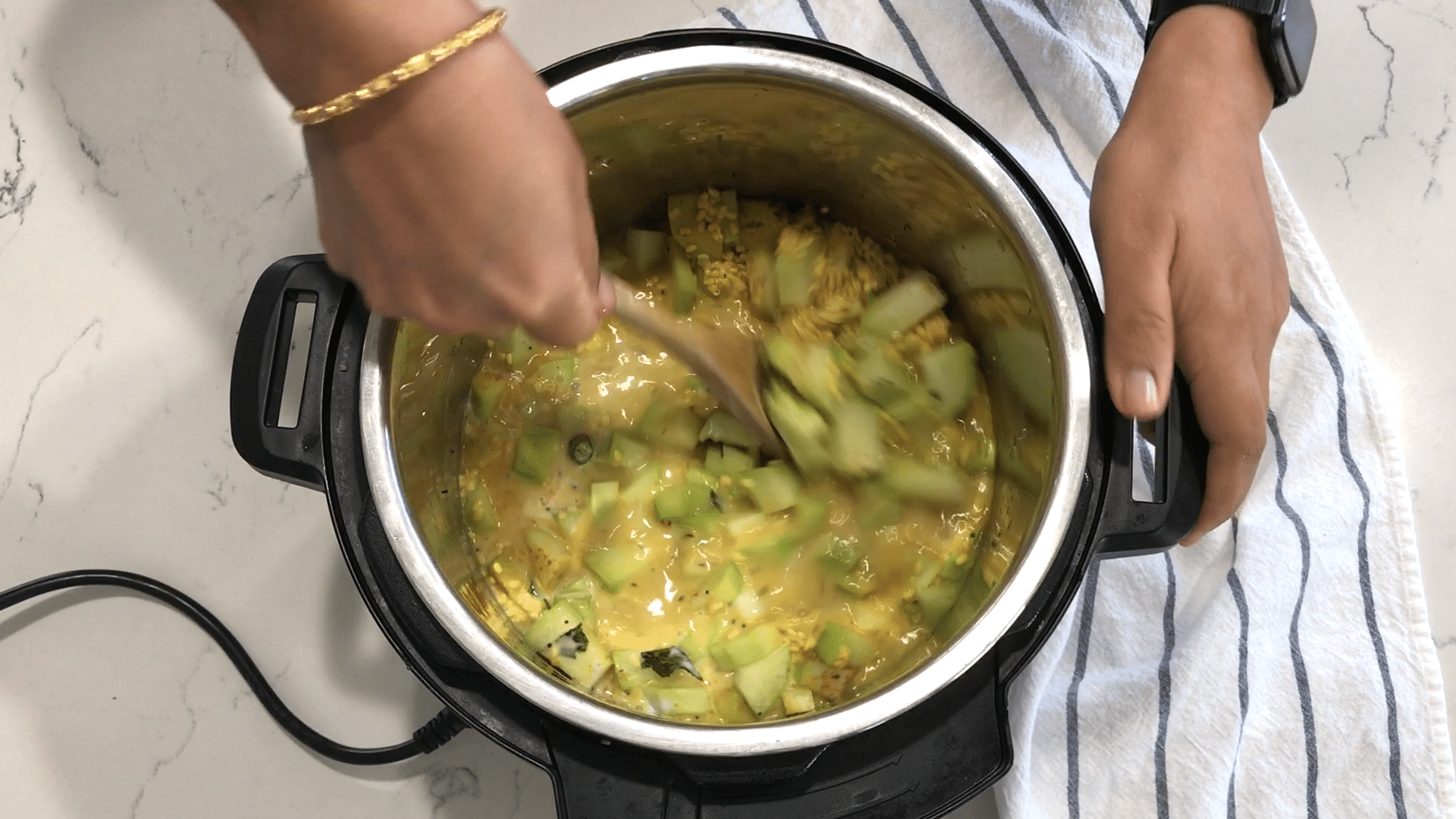 A person cooking food on a stove, with Chayote and Lentil
