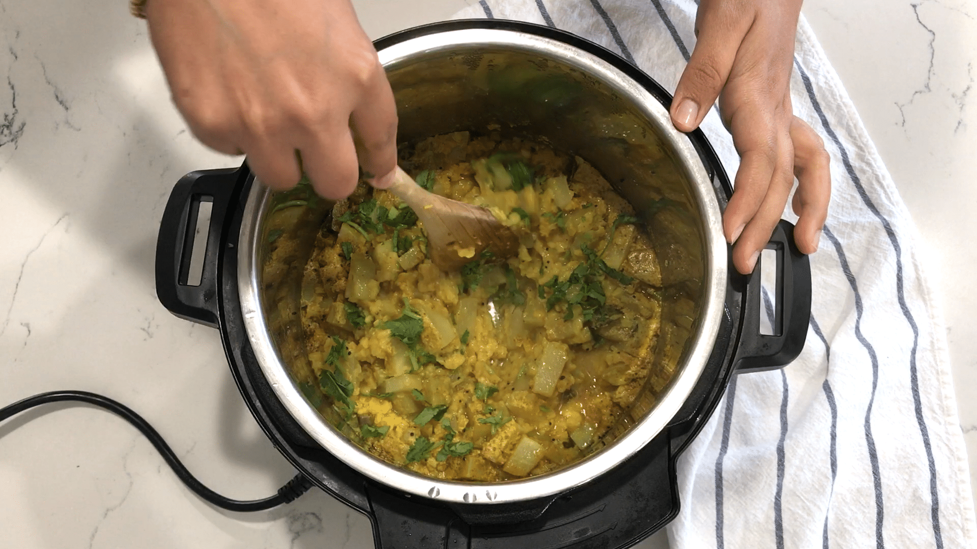 A person cooking food in a pan on a stove, with Chayote and Curry