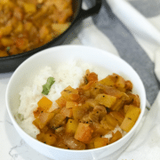 A bowl of food on a table, with Curry and Watermelon