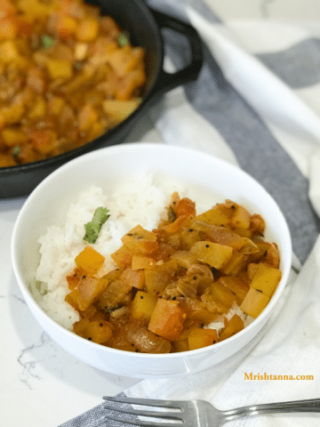 A bowl of food on a table, with Curry and Watermelon