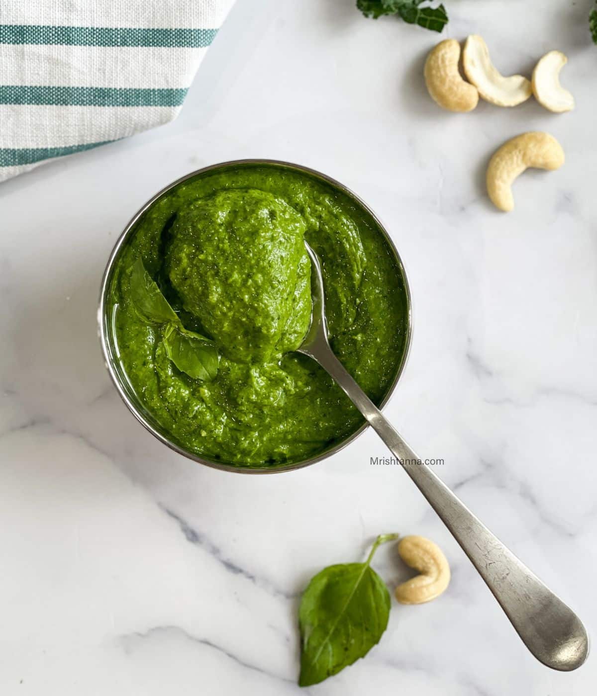 A soon of kale cashew pesto is placed on the bowl.
