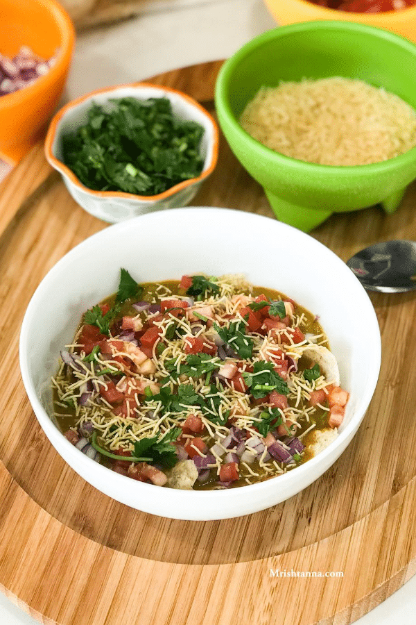 A bowl of food on a table, with Chaat and Masala puri