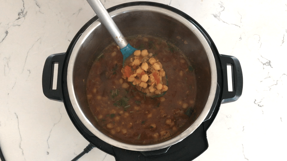 A bowl of curry and a spoon, with Chana masala and Chickpea