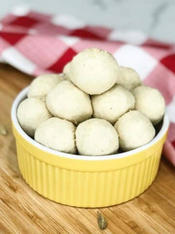 A bowl of badam ladoo is on the wooden tray.