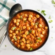 Vegan chana masala is in the bowl topped with cilantro.