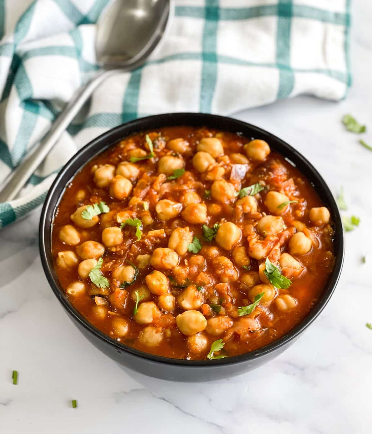 A bowl of vegan chana masala curry is on the table.