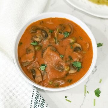 A bowl of curry on the table, with mushroom