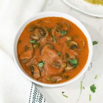 A bowl of curry on the table, with mushroom