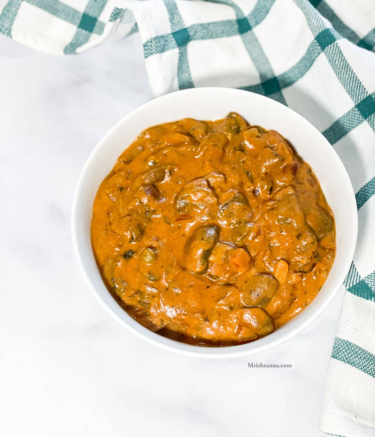 A white bowl is with Instant pot mushroom curry.