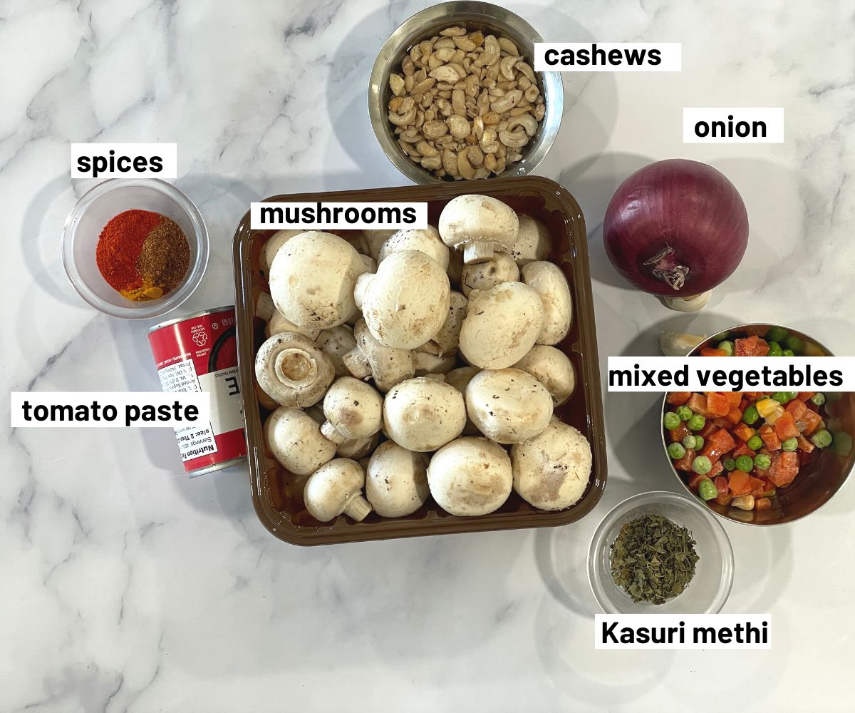 A table is filled with mushroom curry ingredients.