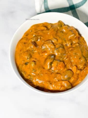 A bowl of Instant pot mushroom masala curry is on the table.