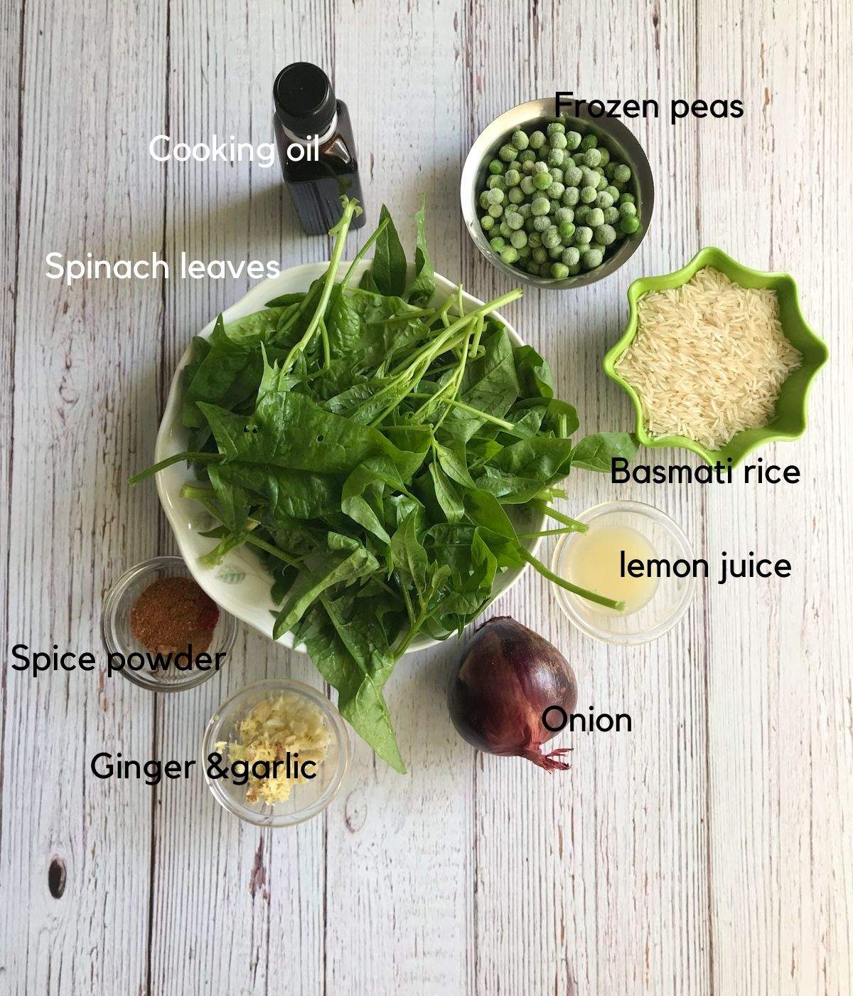 All the ingredients like spinach leaves, spices, rice, oil and onions are on the table