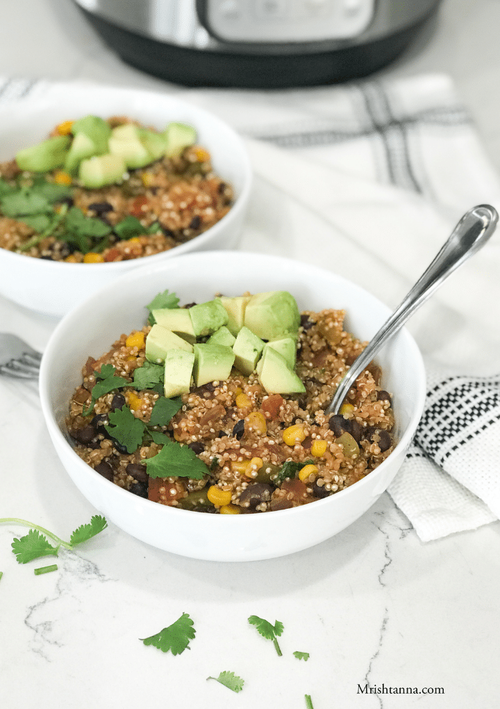 A bowl filled with Mexican quinoa and topped with avocado