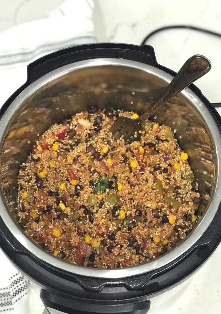An instant pot filled with mexican quinoa and fork inserted