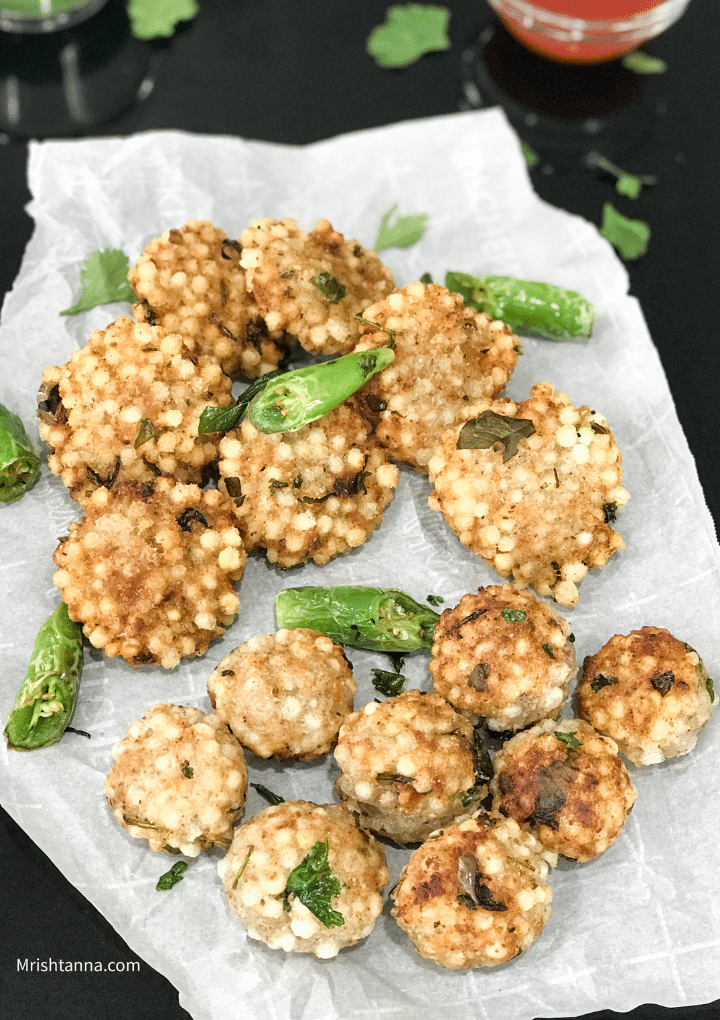 Black tray filled with sabudana vada and tomato sauce