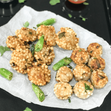 Sabudana Vada placed on the white paper along with chilies