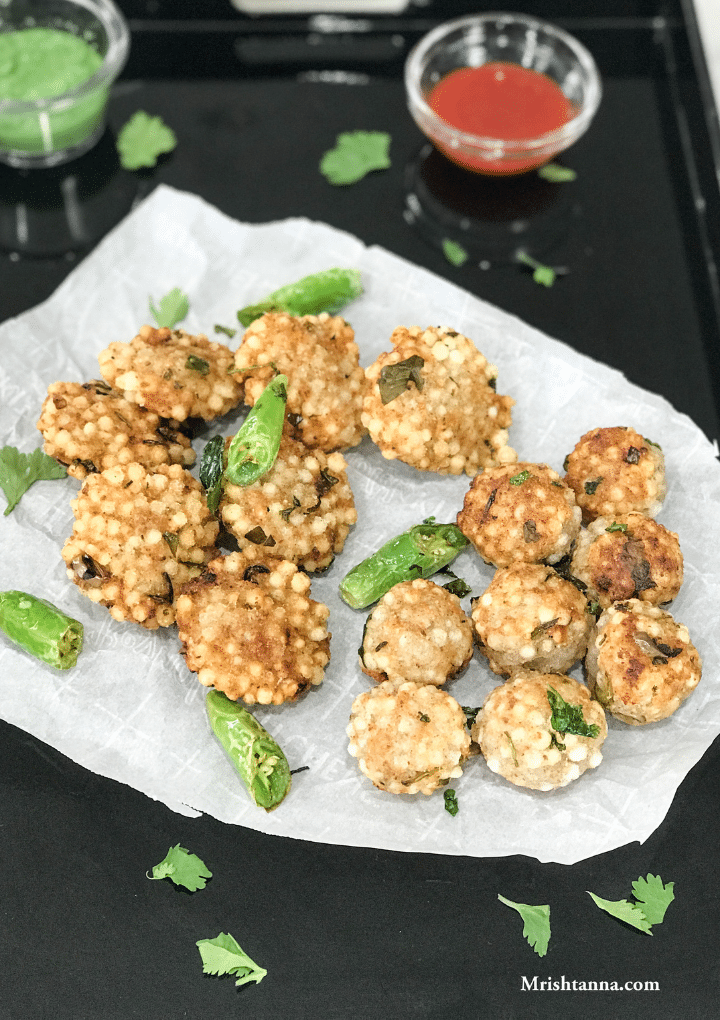 Sabudana Vada placed on the white paper along with chilies