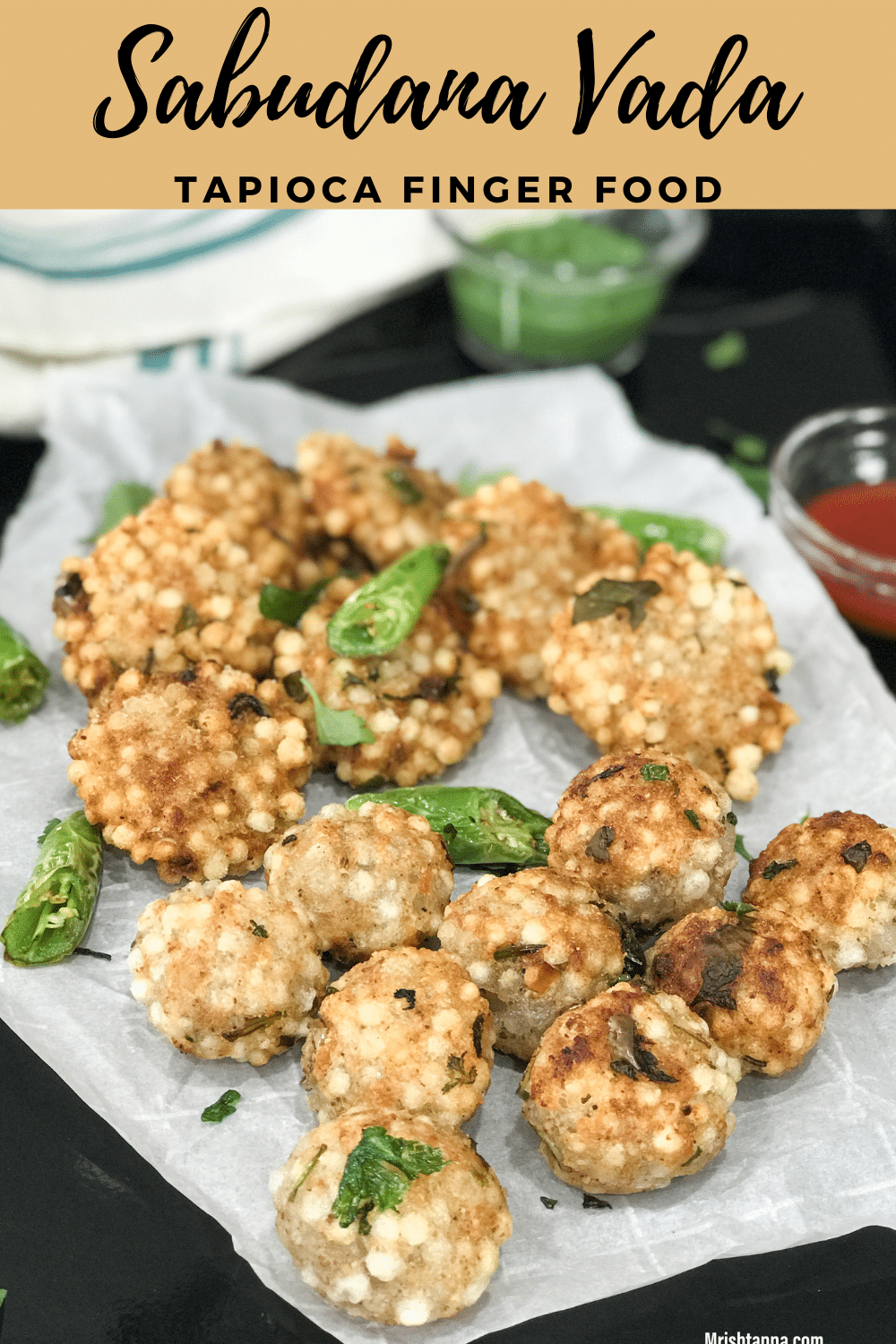 A black tray filled with crispy sabudana vada along with green chutney