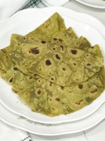 Avocado paratha is placed on a white plate