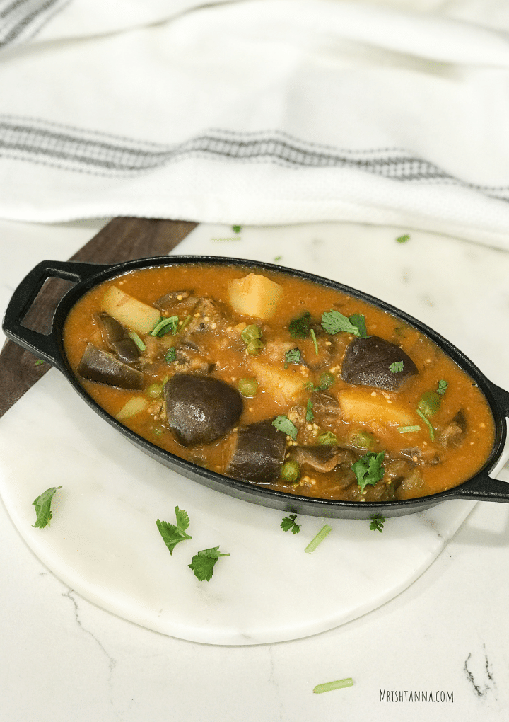 A cast iron bowl filled with eggplant curry