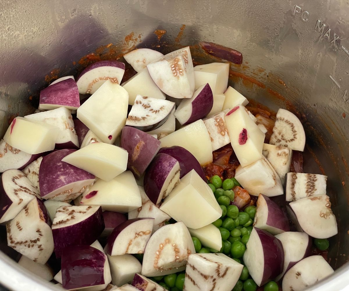 An Instant pot is with eggplants and potatoes.