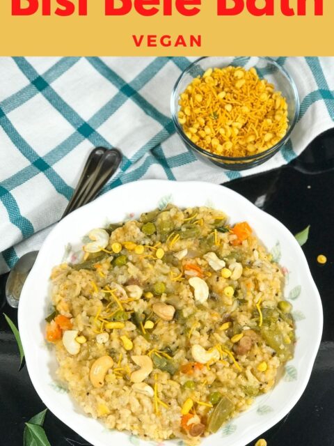 A plate is filled with bisi bele bath and topped with cashews