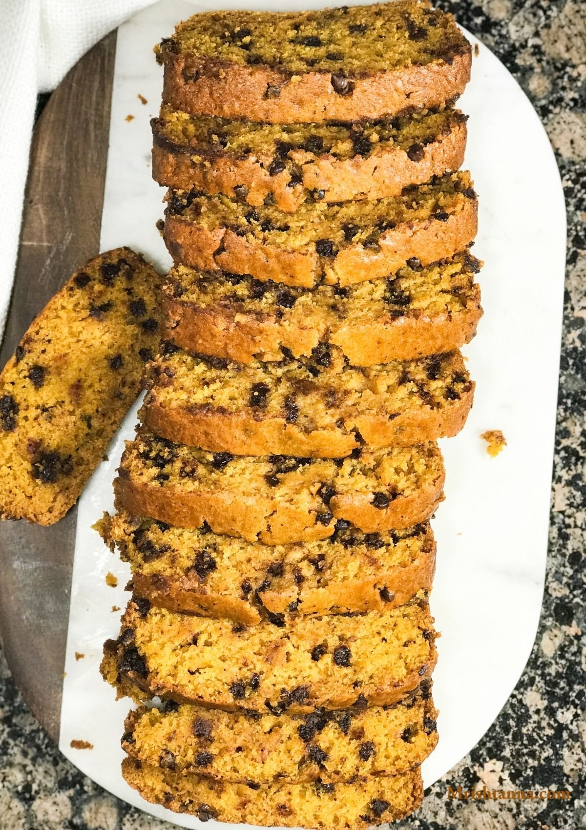 Sliced pumpkin bread is placed on a white serving tray