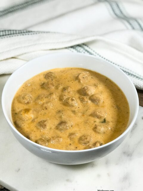 A bowl of meal maker curry is on the white serving tray